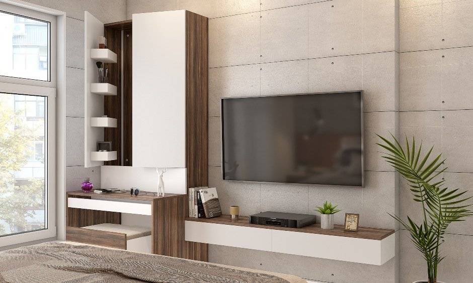 1 bhk bedroom design with floating tv unit and dressing unit lends a minimalistic look.