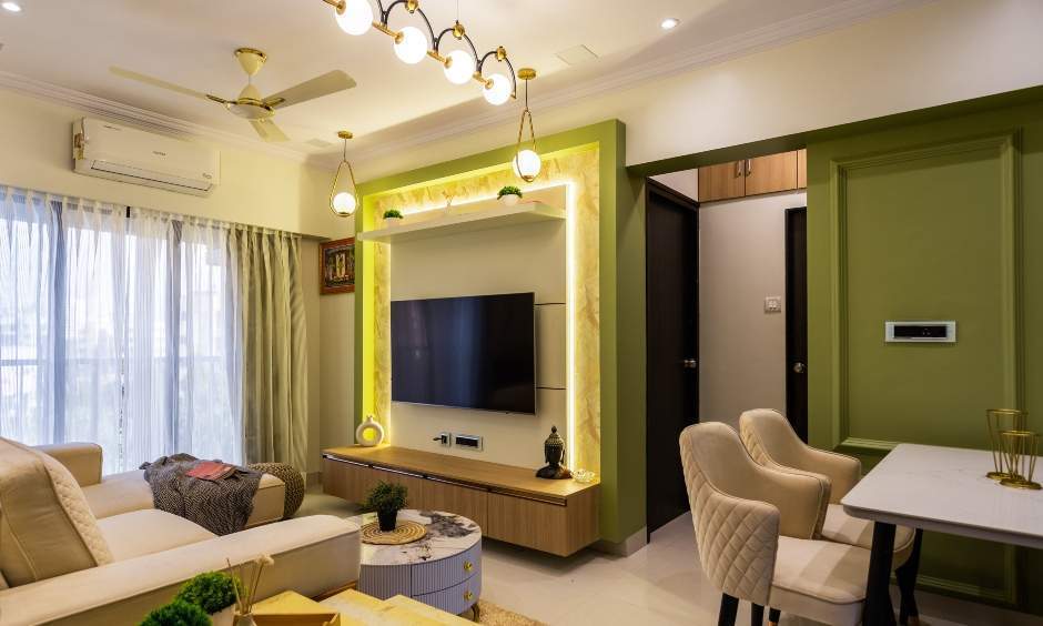 Green-toned living interior design with cove lighting and wooden cabinet in Kandivali, Mumbai.