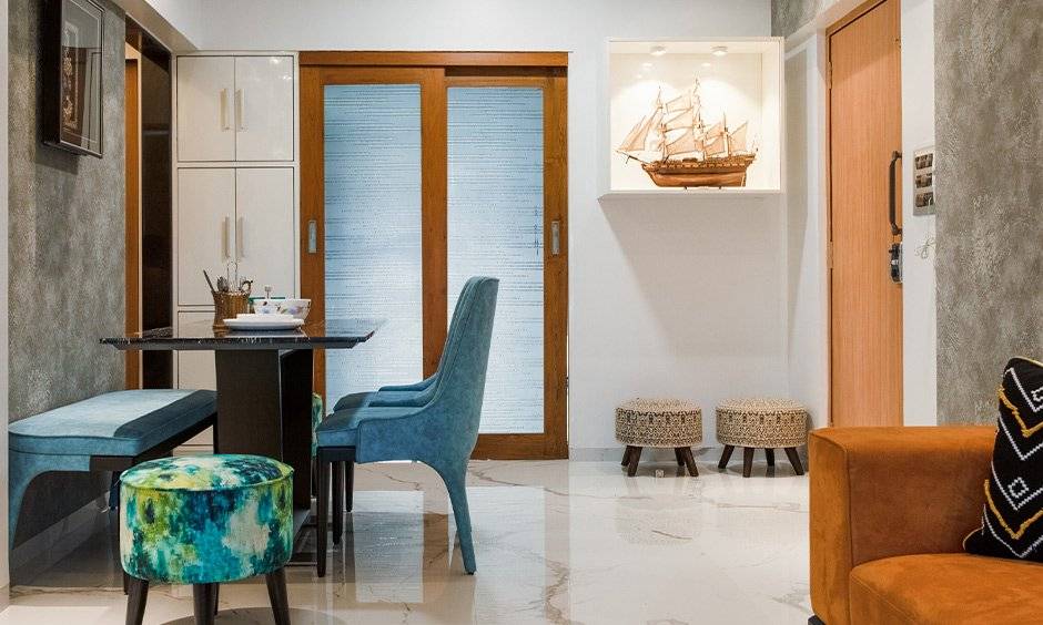 Living room with cabinet and dining table designed by best interior decorators in mumbai