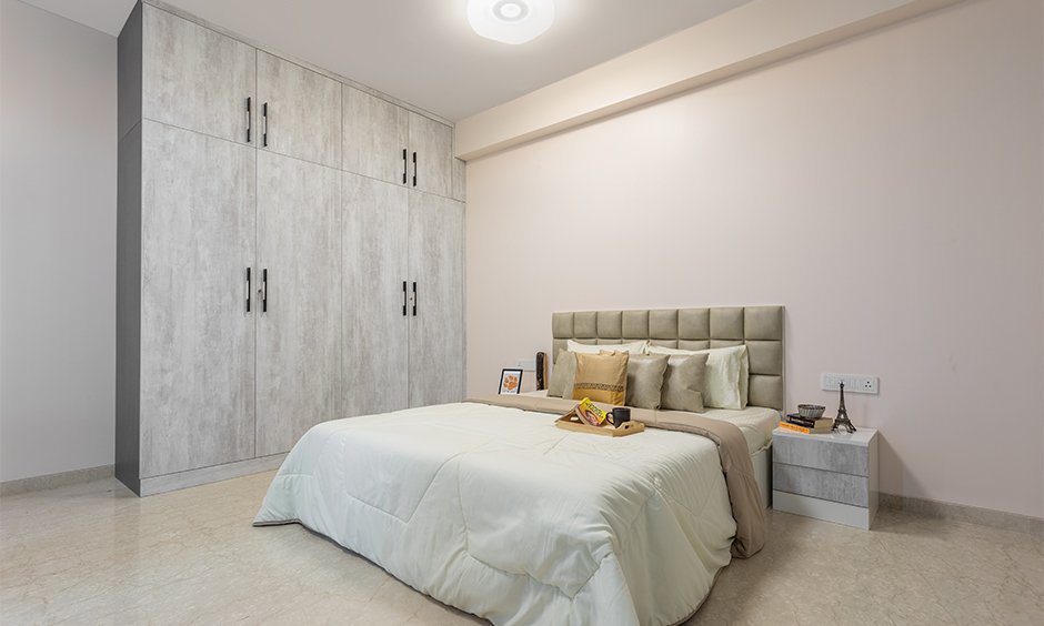 Designed in neutral colours with a leather headboard and a floor-to-ceiling wardrobe by leading interior designers in mumbai