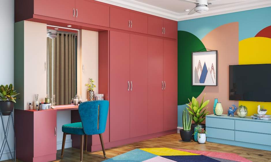 A floor-to-ceiling wardrobe in earthy pink with an attached dressing unit is a smart utilisation wardrobe design