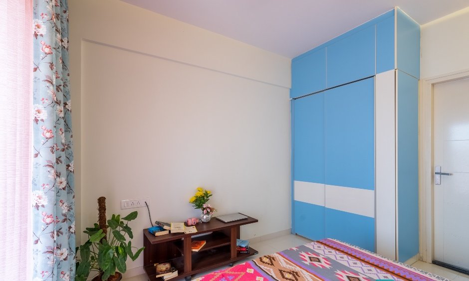A guest bedroom in 2bhk interior with blue wardrobe design