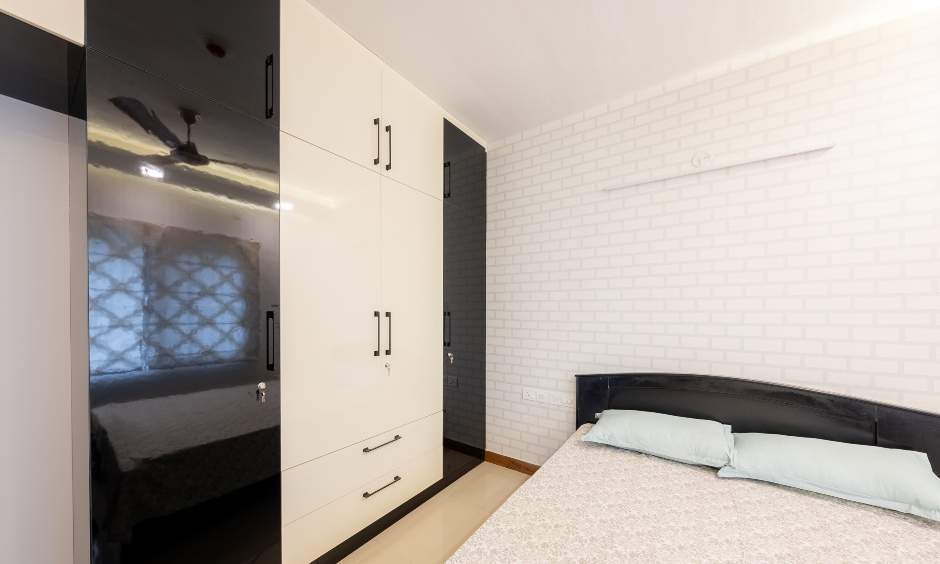 Stylish second bedroom with a dual-colored sliding wardrobe and chic brick wallpaper