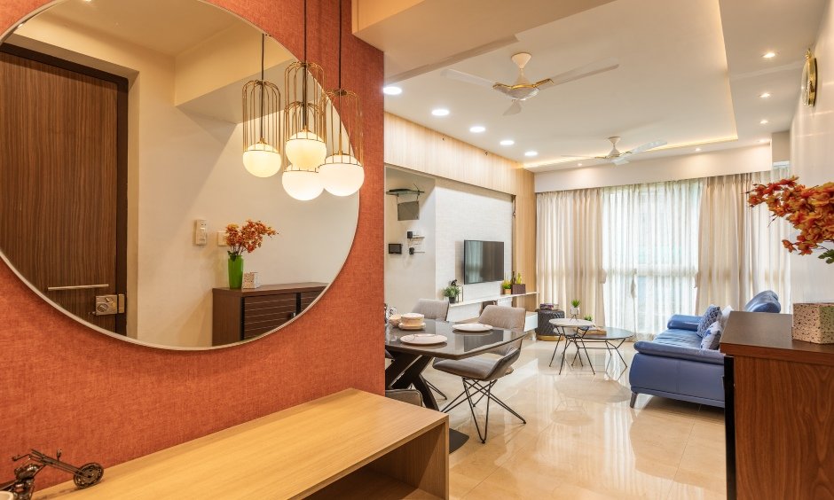Stunning foyer area comes with a classy round shaped mirror by residential interior designers in mumbai
