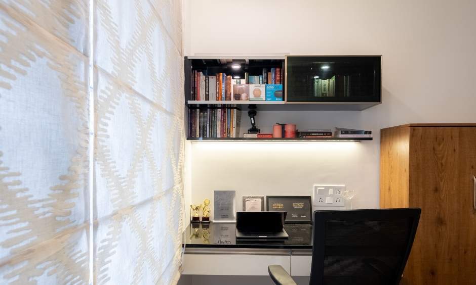Modern workstation with a wall-mounted floating desk and glass top in a 3bhk flat designed by DesignCafe